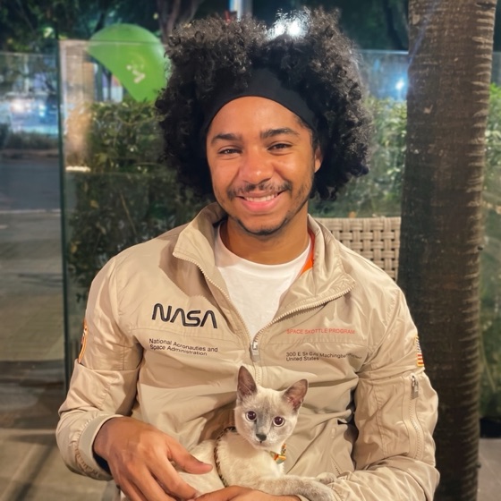 Diego Vieira, fundador da DVS, sorrindo, com um gato no colo